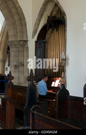 A man playing the organ in St. Egelwin`s Church, Scalford, Leicestershire, England, UK Stock Photo
